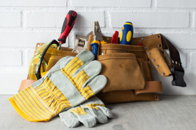 gant de bricolage et sacoche de bricolage en cuir marron avec des outils de bricolage à l'intérieur